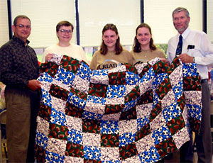 The Garcia family presents Ken Ham with their handmade quilts.