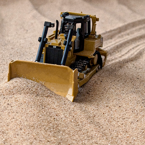 Toy bulldozer in the sand