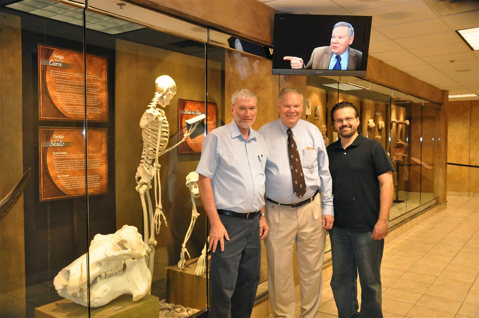 Dr. Menton with Ken Ham and Doug Henderson in front of his homology exhibit