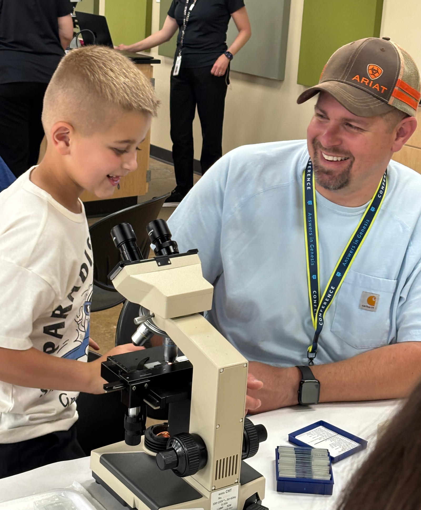 Boy and dad by a microscope.