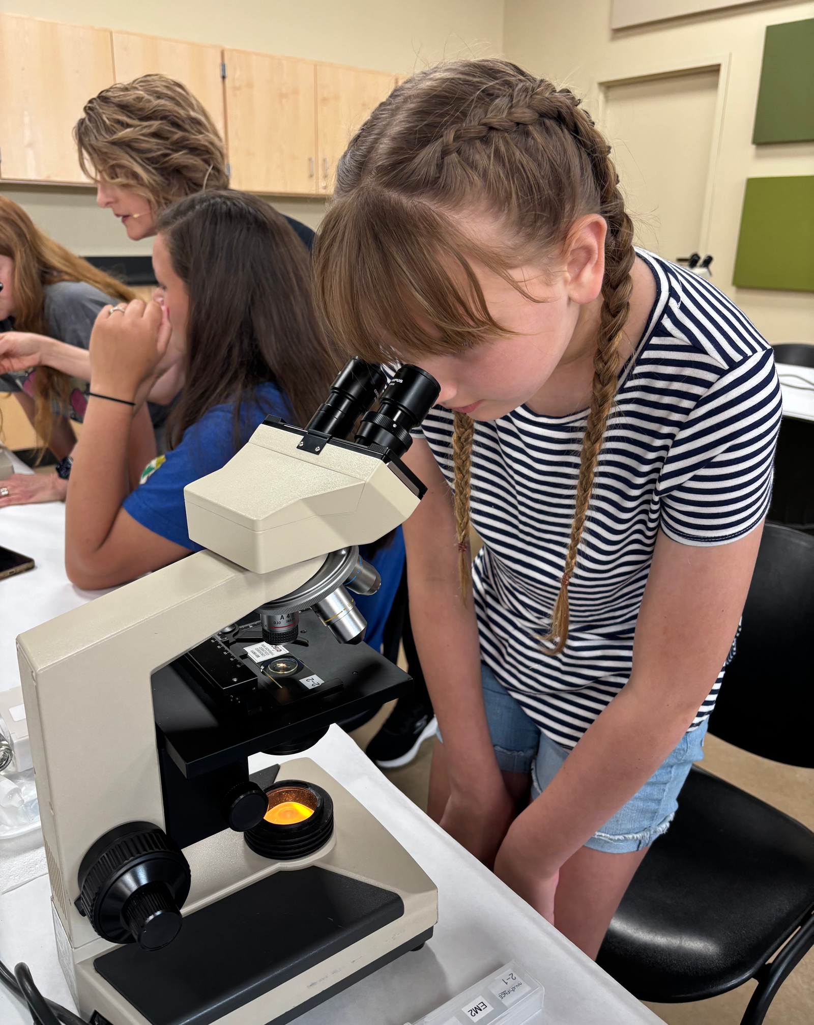 Girl looking into microscope.
