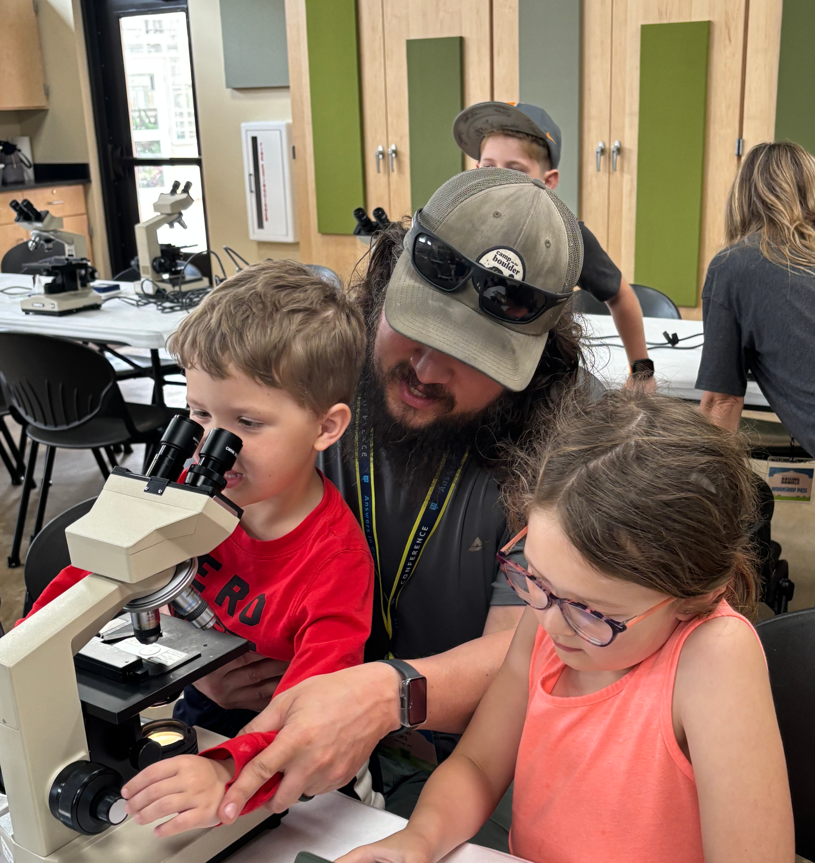 Dad and kids by a microscope.