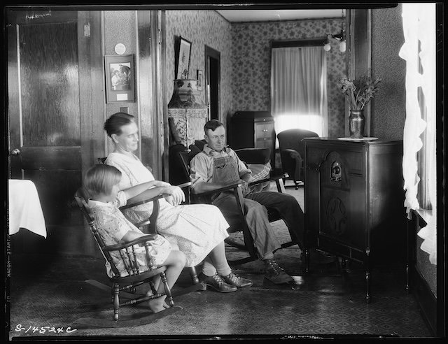 A family gathered around their radio