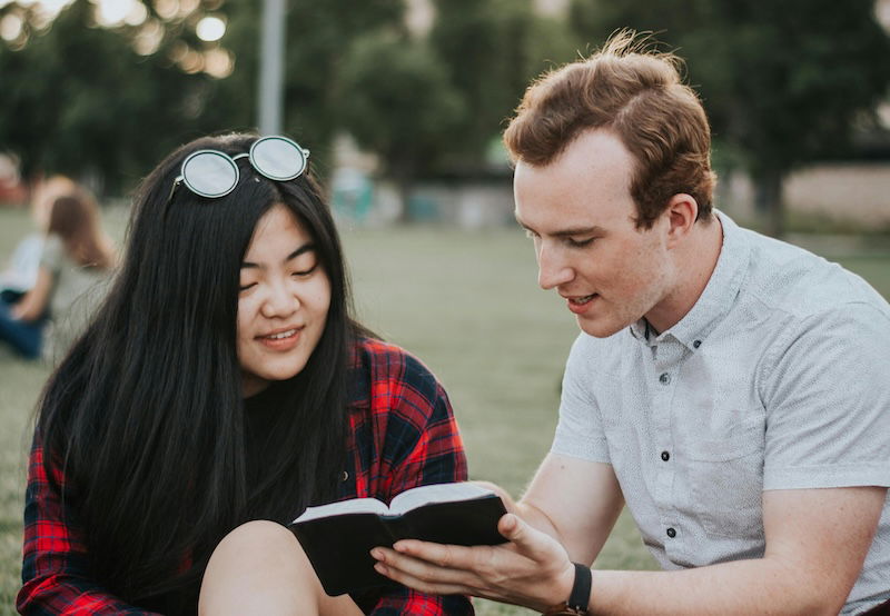 Boy showing girl Bible verses