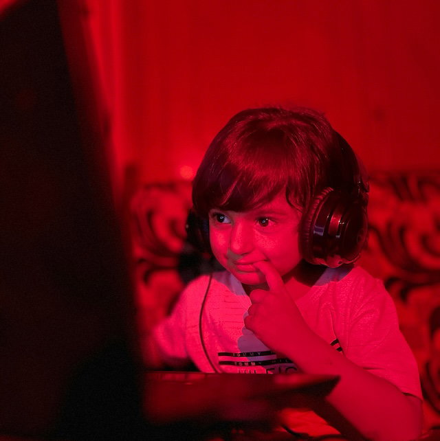 A boy looking at a laptop