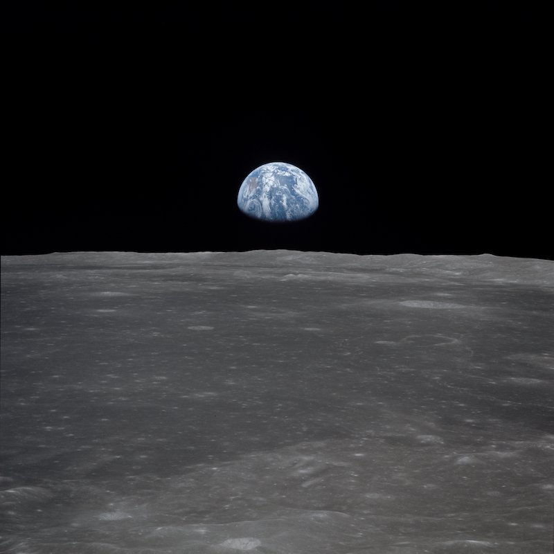 Image from the Apollo 11 spacecraft, showing the earth rising above the moon’s horizon