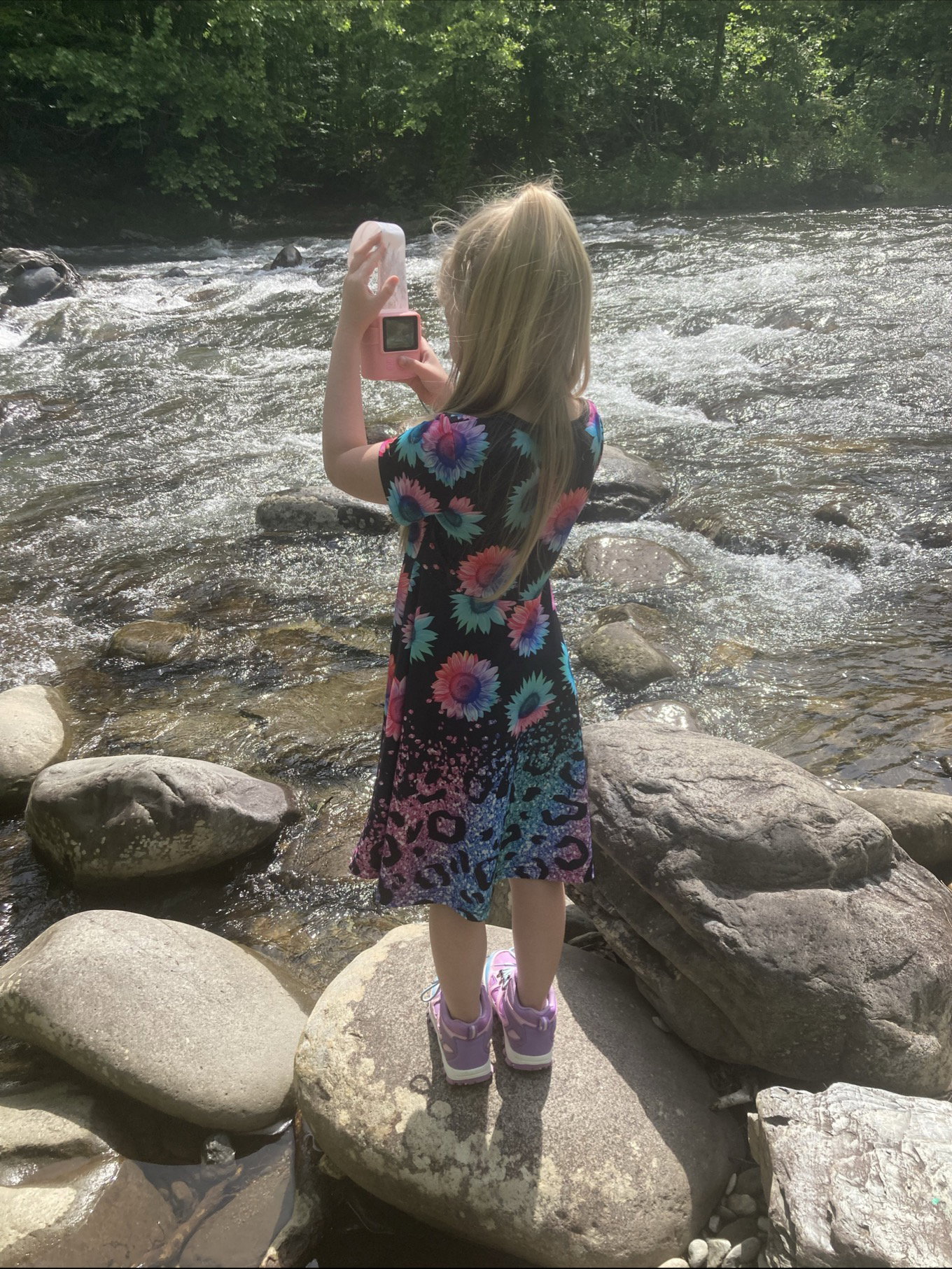 Girl taking photo of river