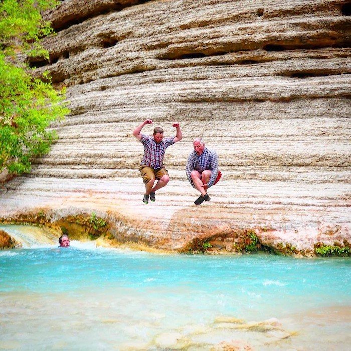 Two men jumping into the Grand Canyon river
