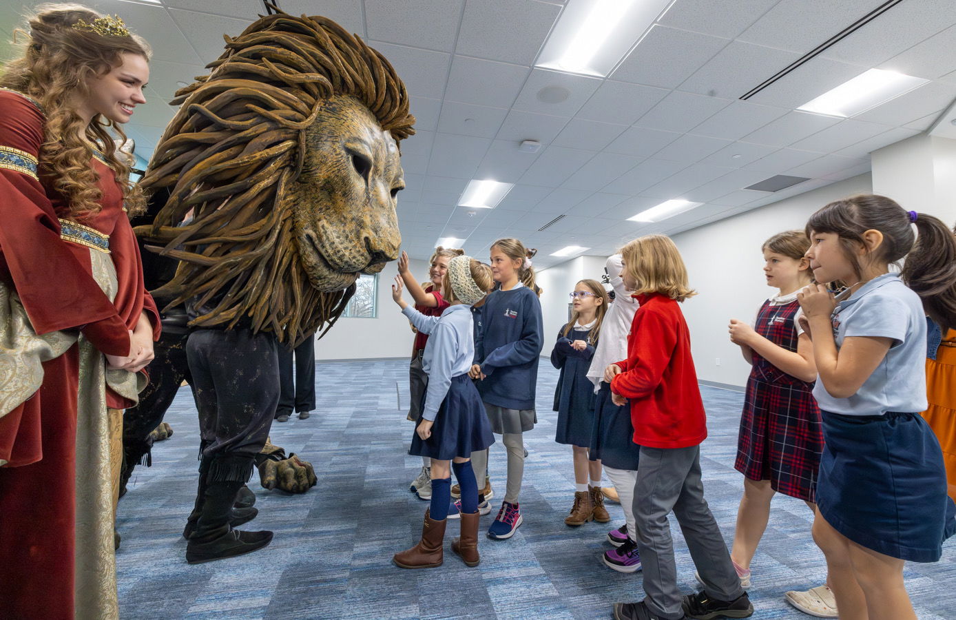 Students petting life-size Aslan puppet