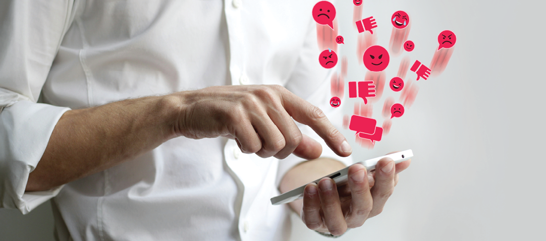 person holding phone with angry emojis shown