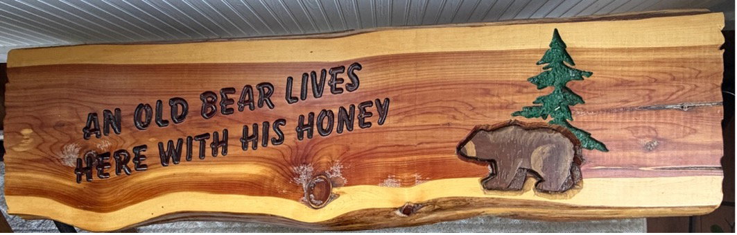 log seat that says, “An old bear lives here with his honey”