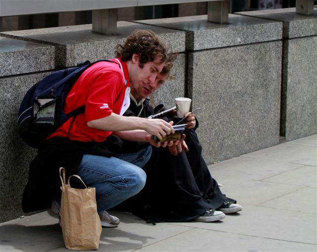 Matthew T. sharing a booklet with a man on the street.