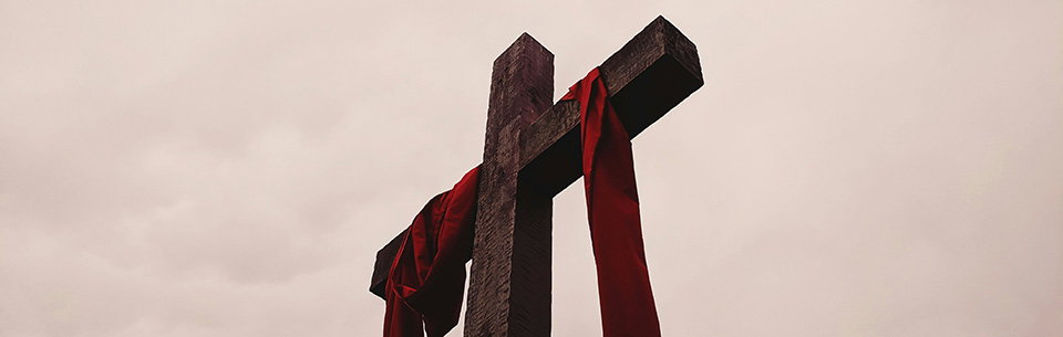 low angle view of cross with red garment