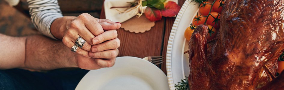 Holding hands next to Thanksgiving turkey