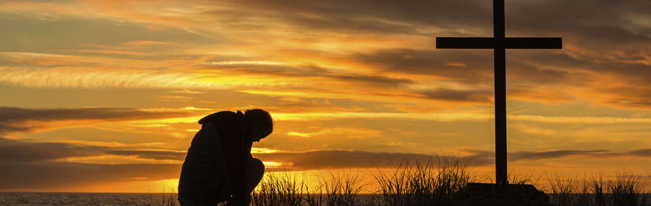 Man Kneeling in Front of Cross