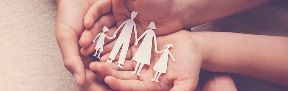 Paper cut-out family in kid's hands
