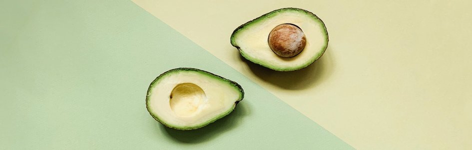 Sliced avocado on green and yellow background